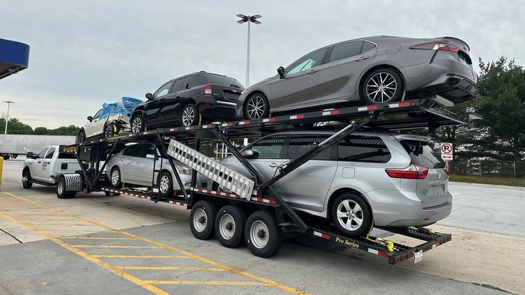 Open car hauler trailer loaded with vehicles in a parking lot
